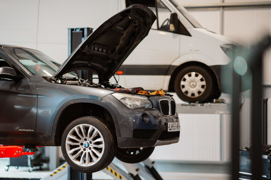 A car and a van on vehicles lifts