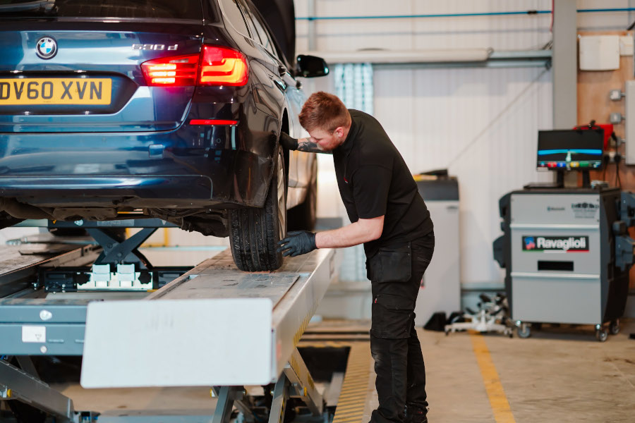 A mechanic inspecting car tyres